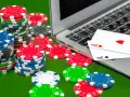 Stosy żetonów do pokera i karty na laptopie. Czy zakłady bukmacherskie to hazard? To pytanie zadaje sobie wielu graczy.
