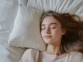 Spokojny sen dziewczyny na poduszce, symbolizujący **regulowanie emocji** i odpoczynek.