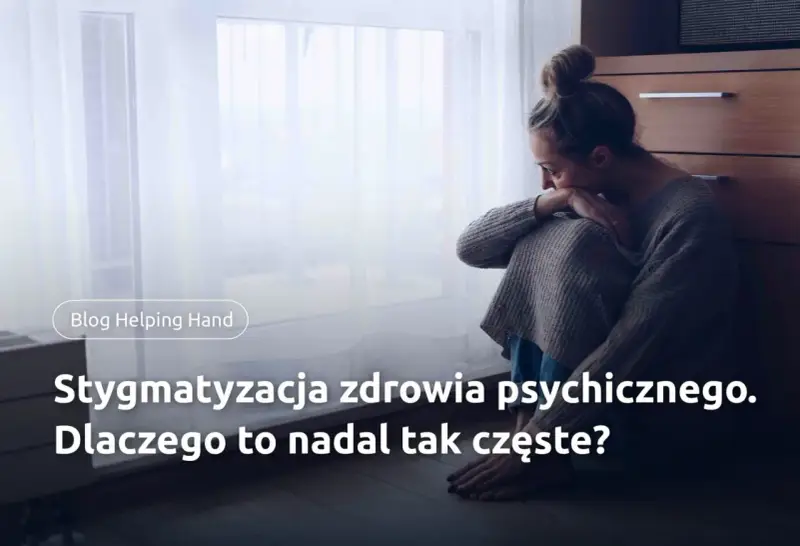 Smutna kobieta siedzi przy oknie. Stygmatyzacja zdrowia psychicznego to wciąż problem.
